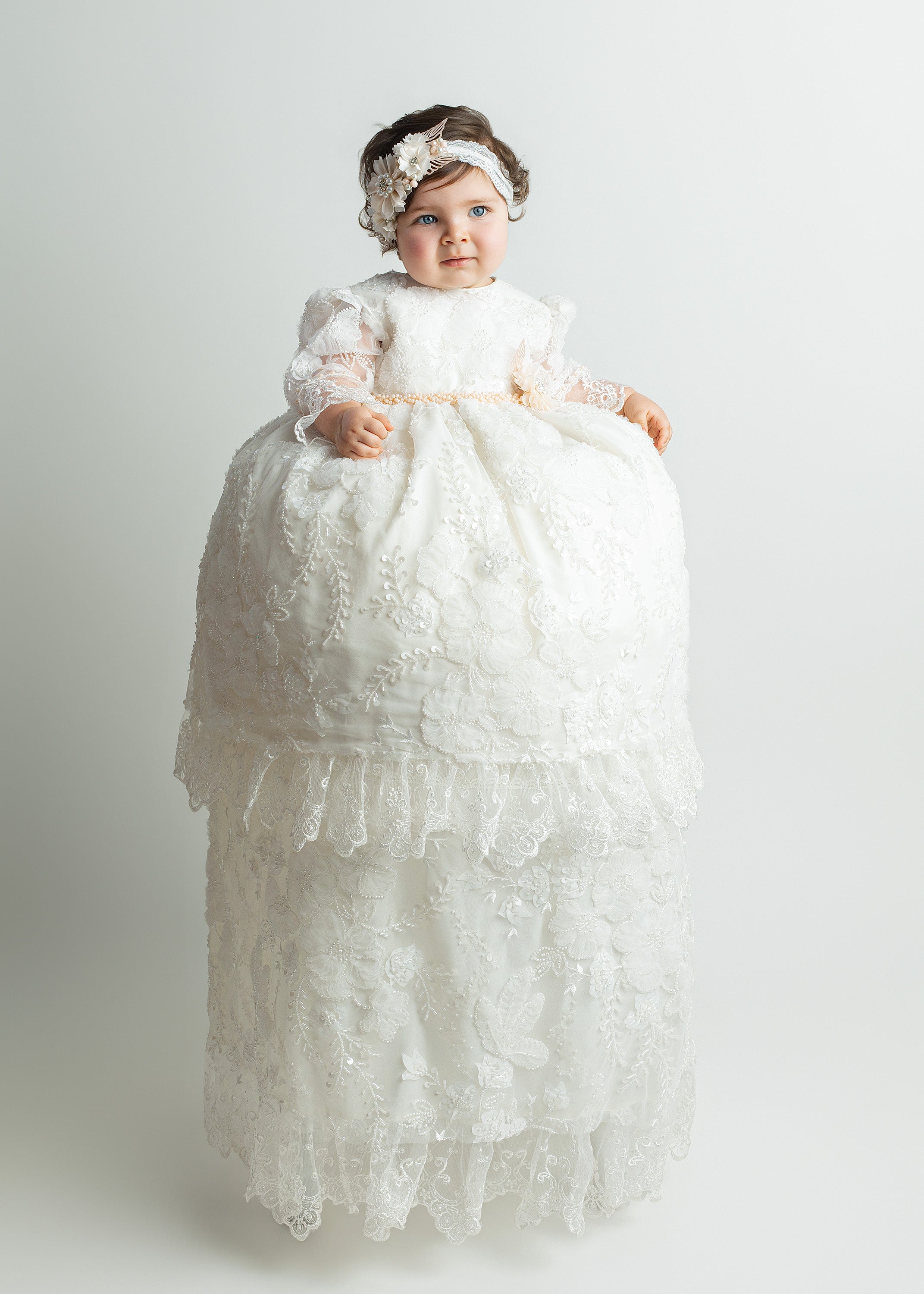 Baby girl wearing G064 ivory baptism gown with floral embroidery and detachable long skirt